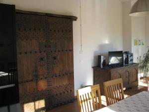 a dining room with a table and a wooden door at Belvilla by OYO House with large terrace and pool in Bastia Mondovì