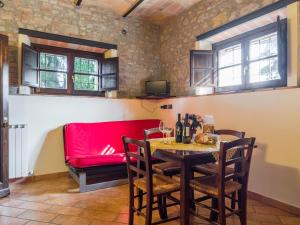 una sala da pranzo con tavolo e divano rosso di Belvilla by OYO Il Leccio a Perugia