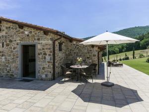 een patio met een parasol en een tafel en stoelen bij Belvilla by OYO Casa Quattro in Poppi