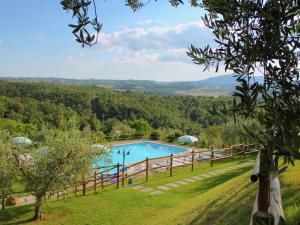 Elle offre une vue sur une piscine entourée d'une clôture et d'arbres. dans l'établissement Farmhouse with air conditioning private terrace and pool, à Città della Pieve