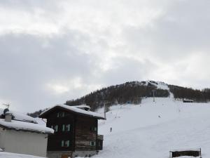 a ski lodge with a snow covered mountain in the background at Belvilla by OYO Casa Marinella in Livigno