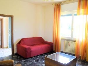 a red couch in a living room with a window at Belvilla by OYO Porto Quarantaquattro in Lazise