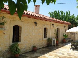 una casa de piedra con mesa y sillas al aire libre en Quaint Holiday Home in Pasalites with Garden near Perama, en Pasalítai