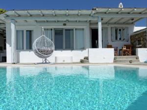 カラファティスにあるBeautiful large luxury villa in Mykonosのブランコ付きスイミングプール、家
