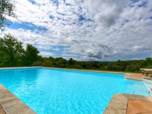 een groot blauw zwembad met een bewolkte hemel bij Belvilla by OYO Villa Sara in Lucignano