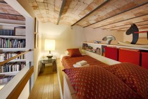 a bedroom with two beds and a book shelf at Habitat Apartments La Bohème in Barcelona