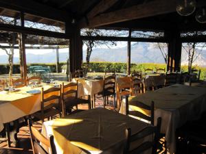 a restaurant with tables and chairs with mountains in the background at Cottage in Intra with Lake and Mountain Views in Verbania