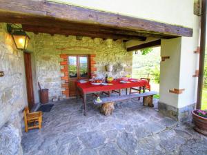 un tavolo rosso e una panca su un patio in pietra di Tranquil Tuscan Retreat a Castel Focognano