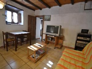uma sala de estar com uma televisão e uma mesa em Belvilla by OYO Conca oro em Marliana