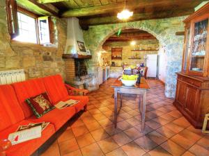 a living room with a red couch and a kitchen at Belvilla by OYO Nonno Raoul in Castel Focognano