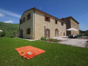 un bâtiment avec une table dans l'herbe devant lui dans l'établissement Belvilla by OYO Rosa Bianca, à Apecchio