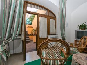 ソレントにあるLavish Mansion in Sorrento with Gardenのドア、椅子、テレビが備わる客室です。