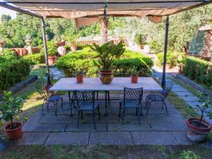 einen Tisch und Stühle unter einem Sonnenschirm in einem Garten in der Unterkunft Belvilla by OYO Nice Farmhouse with Sauna Jacuzzi in Pieve a Nievole