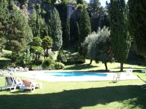Pognana LarioにあるHoliday home with balcony for 2 4 people by lake Como near Pognana Larioの芝生の椅子と木々があるスイミングプール