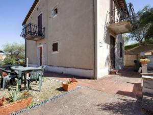 シエナにあるComfortable Mansion in Siena with Swimming Poolの建物の隣にテーブルと椅子付きのパティオ
