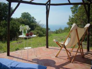een patio met een tafel en 2 stoelen en een tafel bij Belvilla by OYO Comfy Holiday Home with Garden in Monte Argentario