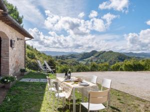 d'une table avec des chaises blanches et d'une vue sur les montagnes. dans l'établissement Belvilla by OYO Borgo Tre, à SantʼAngelo in Vado