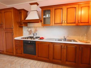 a kitchen with wooden cabinets and a sink at Farmhouse in Sorano with Swimming Pool Terrace Barbecue in Sorano