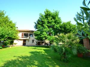 una casa con un cortile verde davanti di Belvilla by OYO Serena a Marina di Massa