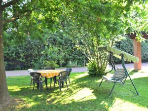 un tavolo e sedie in erba sotto un albero di Belvilla by OYO Serena a Marina di Massa