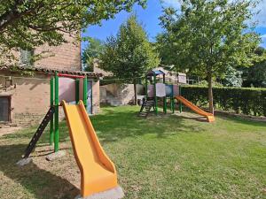 un parque infantil con un tobogán en un patio en Serene Holiday Home in Piticchio with pool and scenic views en Arcevia