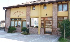 un edificio di mattoni con un cartello sulla parte anteriore di Agriturismo Ai Due Volti a Dossobuono