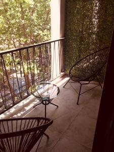 uma varanda com 2 cadeiras e uma mesa de vidro em Studio II em Belén de Escobar