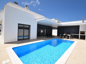 a swimming pool in the backyard of a house at Modern villa with private pool near the beautiful beach of Foz de Arelho in Nadadouro