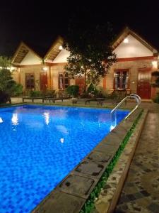 a swimming pool in front of a house at night at Tamcoc Mr. Cau Homestay in Ninh Binh