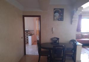 a living room with a table and a dining room at Appartement Chham in Marrakesh