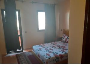 Habitación pequeña con cama y ventana en Appartement Chham, en Marrakech