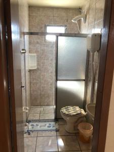a small bathroom with a shower with a toilet at Residencial BomAluguel in Capão da Canoa +34 photos