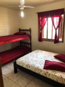 a bedroom with two bunk beds and a window at Residencial BomAluguel in Capão da Canoa