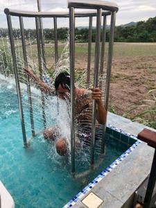 Um homem está na água num baloiço. em Chef Nirvana Spa Pool Villa em Phayayen
