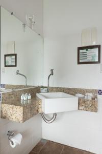 een badkamer met een wastafel en een spiegel bij Pousada Além das Formas in Carrancas