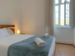 a bedroom with a bed with two towels on it at Guesthouse Tricana de Aveiro in Aveiro