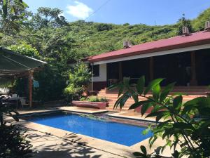 a swimming pool in front of a house at Guesthouse Casa Avi Fauna in Ocotal