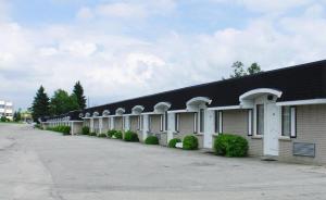 a long building with a black roof and a sidewalk at Travellers Inn in Hanover