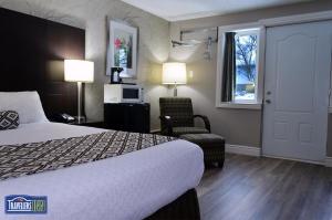 Pokój hotelowy z łóżkiem, krzesłem i oknem w obiekcie Travellers Inn w mieście Hanover