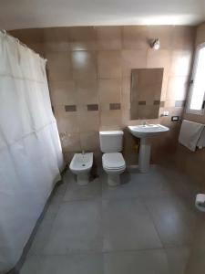 a bathroom with a toilet and a sink at Departamento nuevo 2 dorm, parrilla, cochera in Neuquén