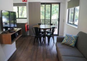 a living room with a table and a couch at Discovery Parks - Airlie Beach in Airlie Beach