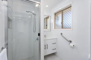 a bathroom with a shower, sink, and toilet at Apollo Lodge in Toowoomba