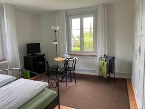 1 dormitorio con mesa, cama y ventana en BnB Hopfengrün Langenthal en Langenthal