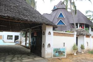 un edificio con techo de paja y un cartel delante en Room in Guest room - A wonderful Beach property in Diani Beach Kenya en Mombasa