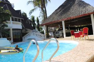 a man laying on a surfboard in a swimming pool at Room in Guest room - A wonderful Beach property in Diani Beach Kenya in Mombasa