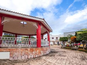 a red building with a balcony on a street at Hotel Las Brisas in Catemaco