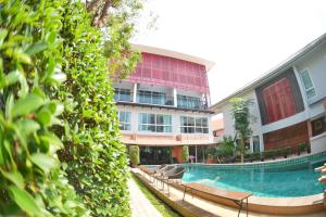 a building with a swimming pool in front of a building at ตำหนักวิลล่า 10 ห้องนอน พร้อมสระว่ายน้ำส่วนตัว in Pattaya South