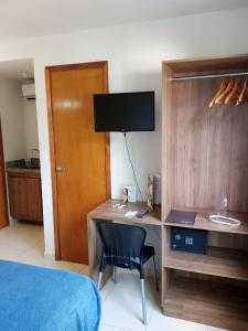 a bedroom with a desk with a computer and a bed at Beira Mar do Cabo Branco com vista 4400 - 310 in João Pessoa