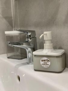 a white soap dispenser sitting on top of a sink at ЭТНО-комплекс Тургояк in Turgoyak