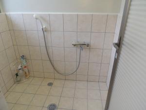 a shower with a hose in a bathroom at びせ崎の宿　海潮音 in Motobu